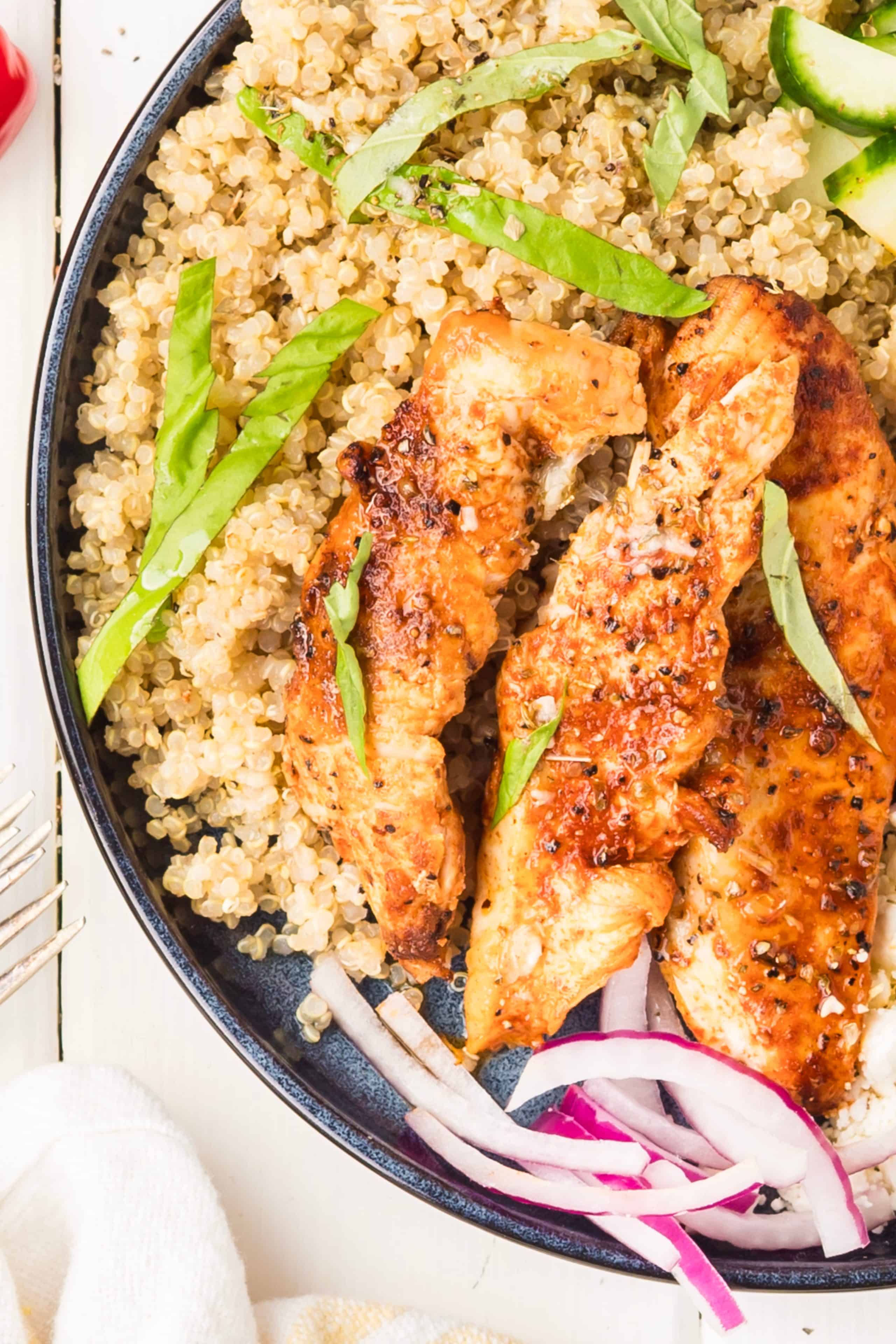 Mediterranean chicken bowl with grilled chicken, quinoa, cucumber, tomatoes, feta, Kalamata olives, red onion, basil, and lemon vinaigrette.