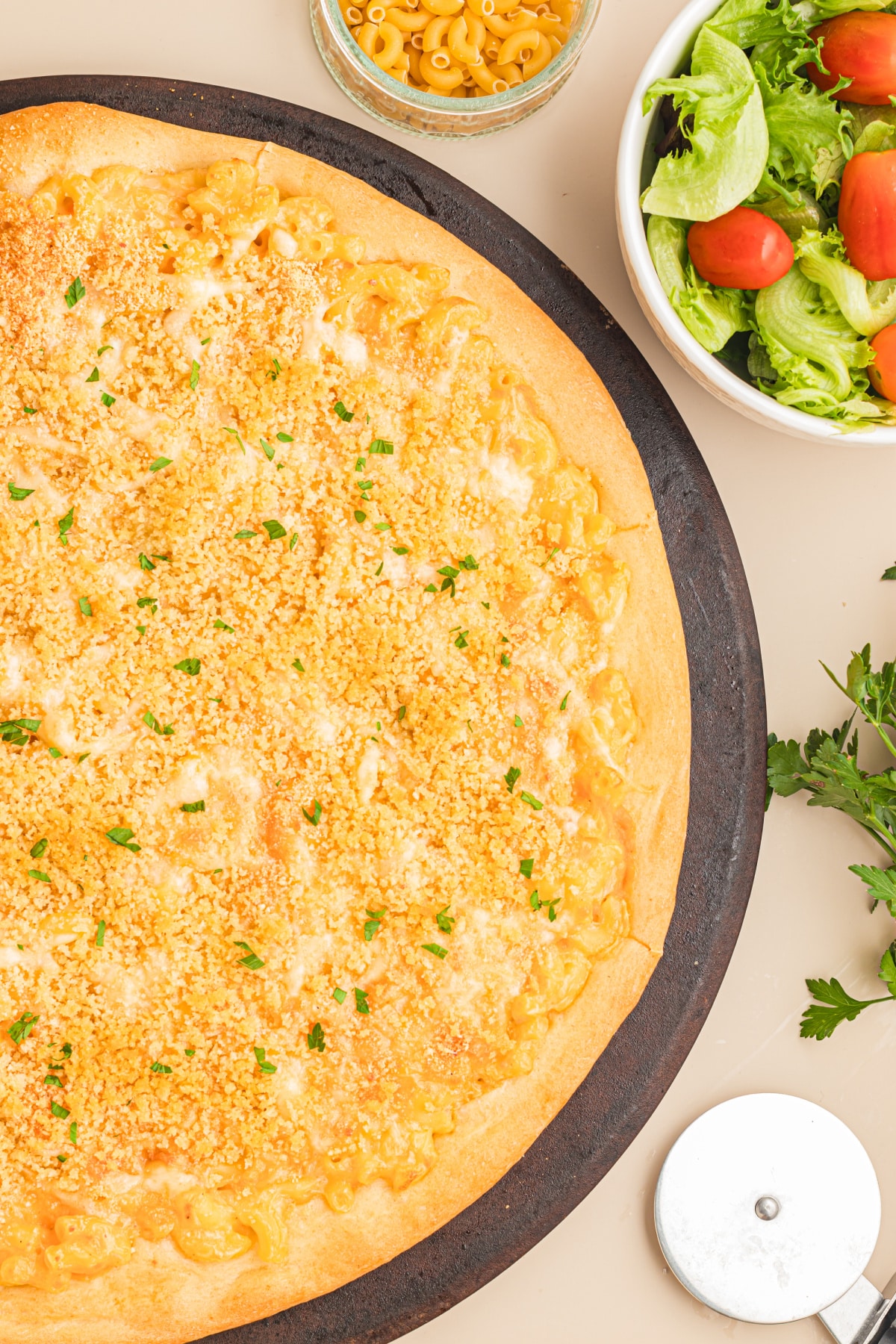 Homemade mac and cheese pizza fresh from the oven with a golden buttery breadcrumb topping and crisp pizza crust.