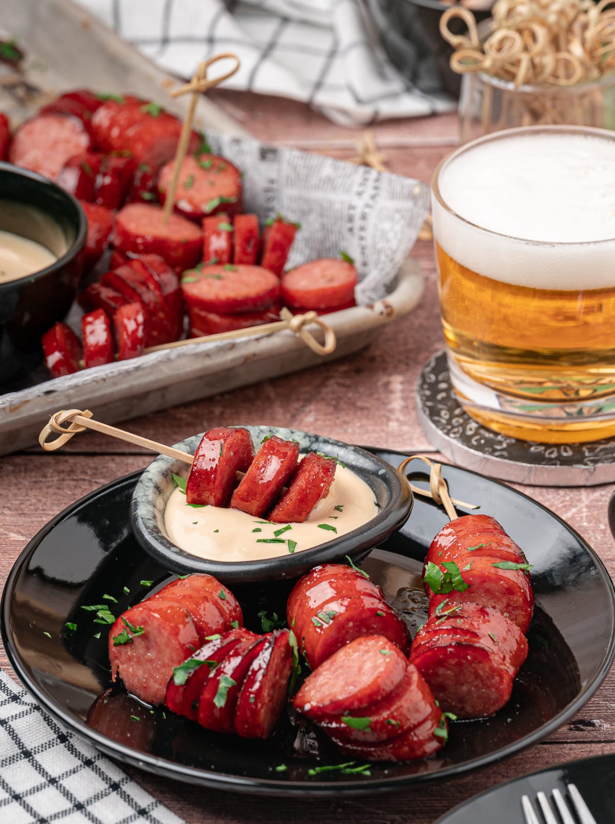 Honey garlic kielbasa bites served with creamy honey mustard and a cold beer.