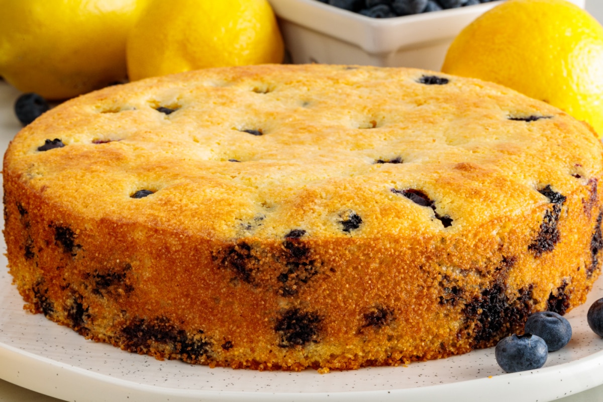 Side view of lemon blueberry cornbread with a golden crust and fresh blueberries baked throughout.