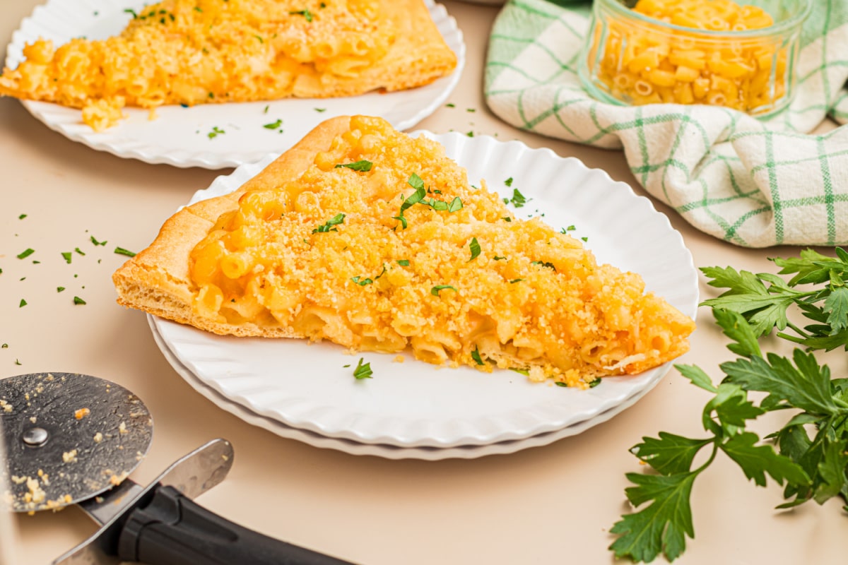 Single slice of homemade mac and cheese pizza with creamy cheddar macaroni, buttery panko breadcrumbs, and a crisp pizza crust.