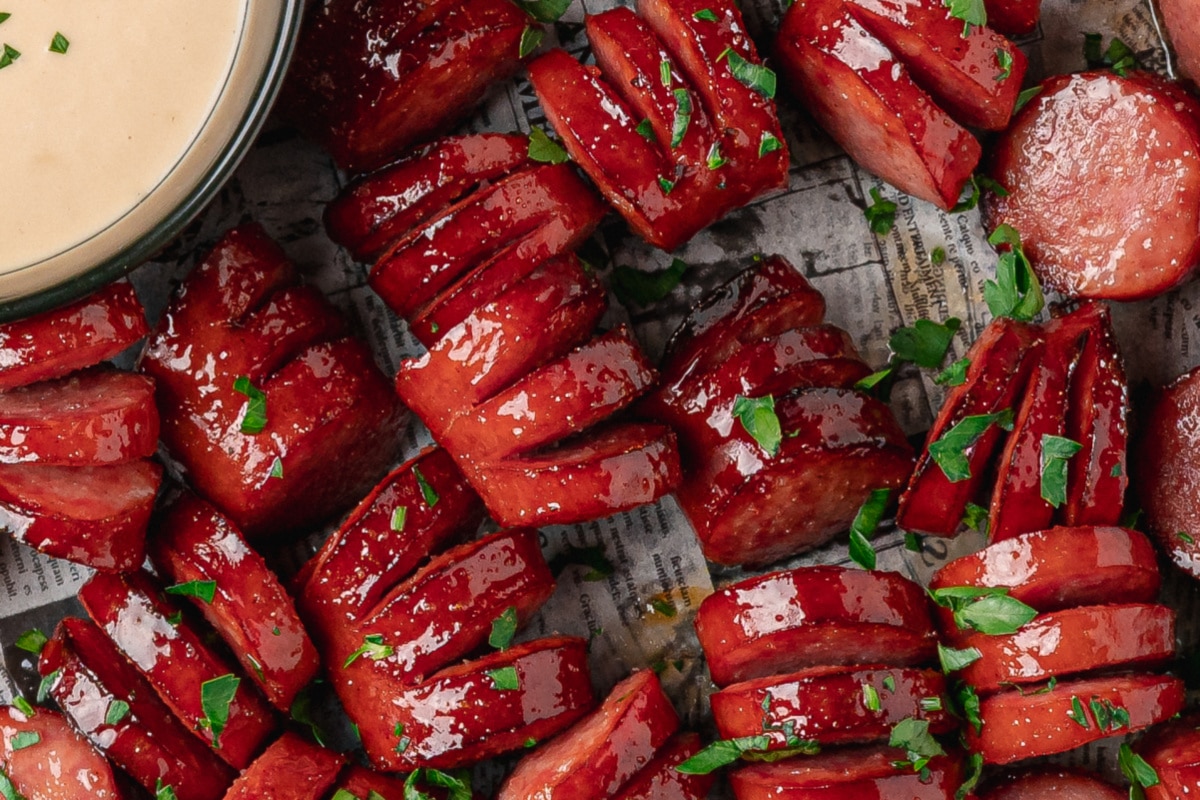 Close-up of sticky honey garlic kielbasa bites with glossy hasselback cuts.