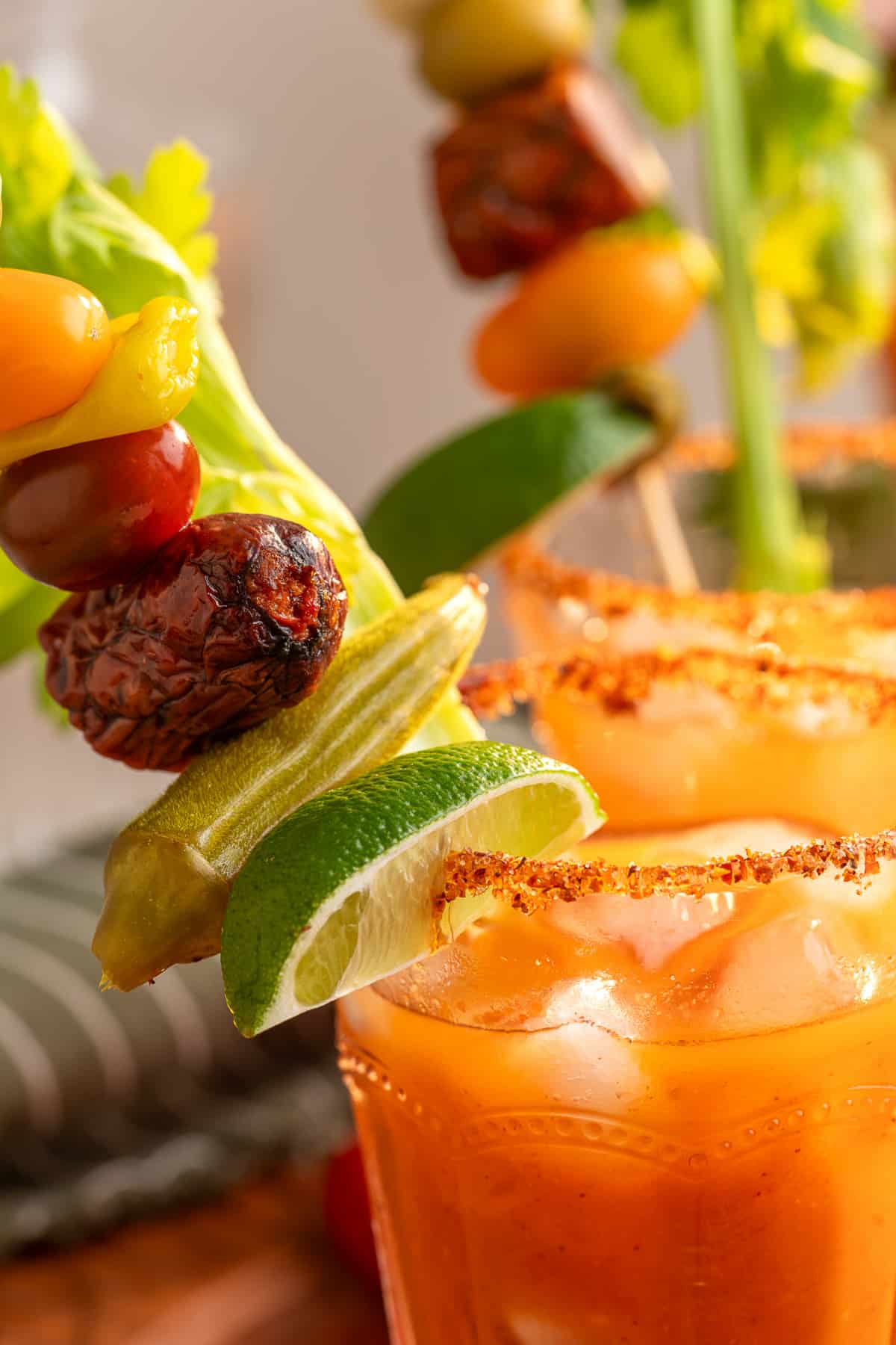 Bloody Mary cocktail with a Tajín rim, celery, lime, pickled okra, tomatoes and smoked sausage garnish