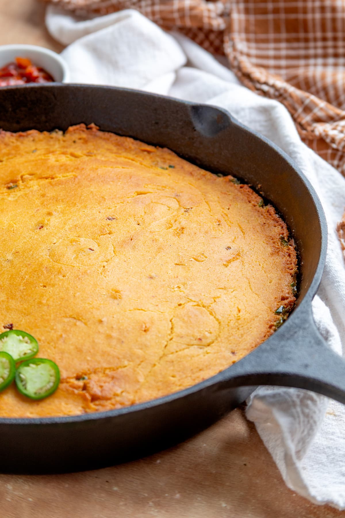 Chipotle cornbread baked in a cast-iron skillet with fresh jalapeños visible around the cornbread