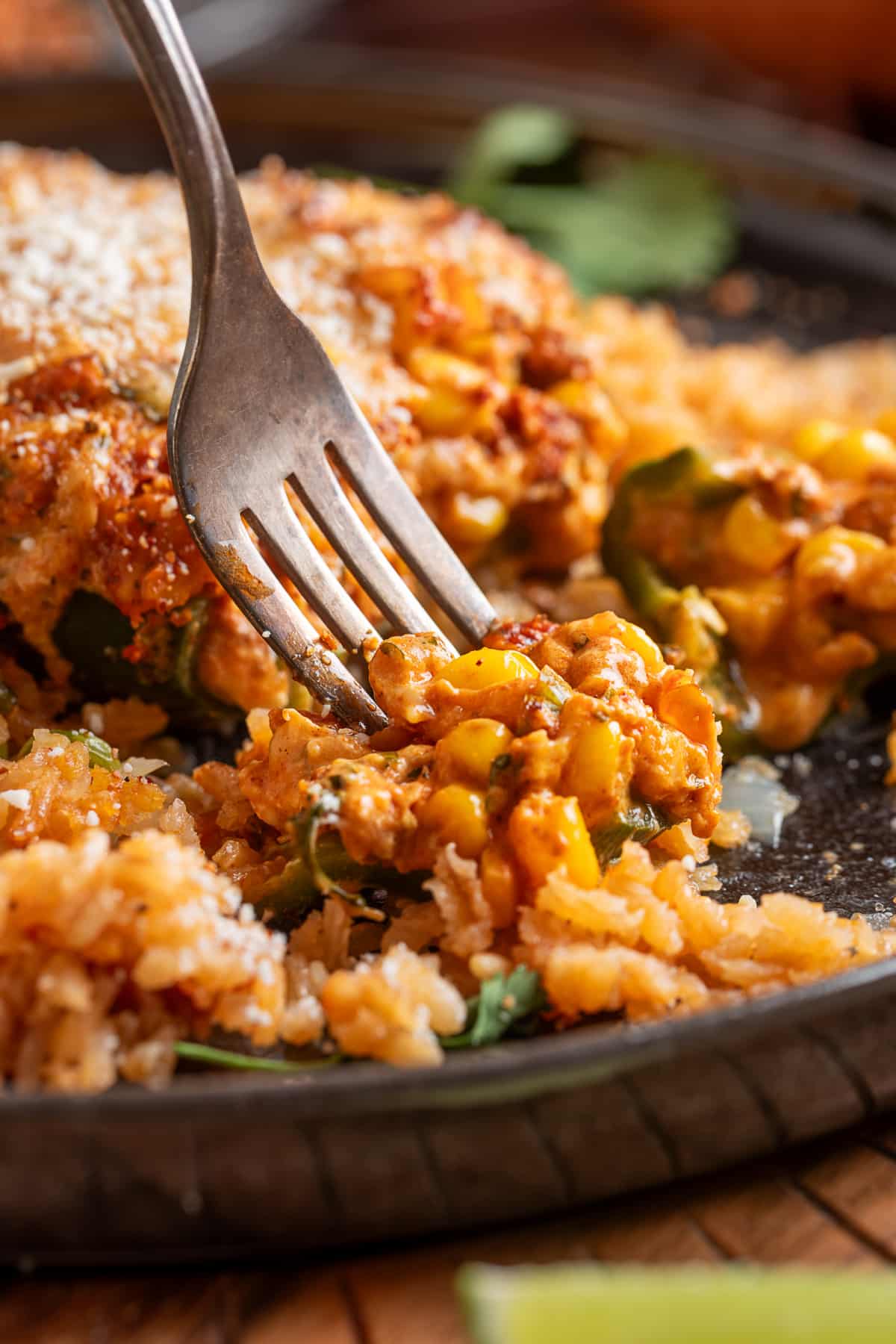 Elote-style poblano stuffed with creamy corn, chorizo and cheese with lime served alongside Stuffed poblano pepper cut open with creamy chorizo, corn, jalapeño and cheese filling served over rice