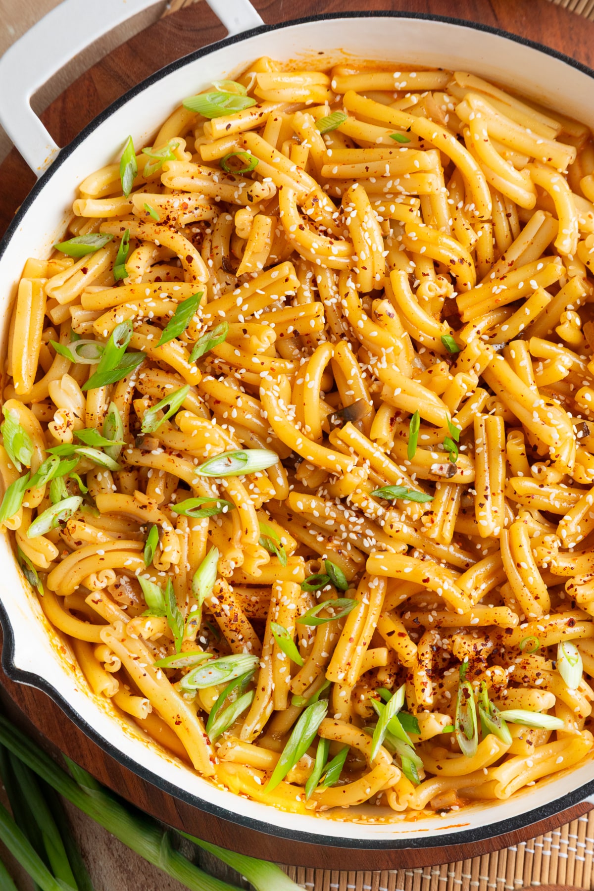 Creamy gochujang pasta with mushrooms, green onions, sesame seeds and gochugaru in a skillet