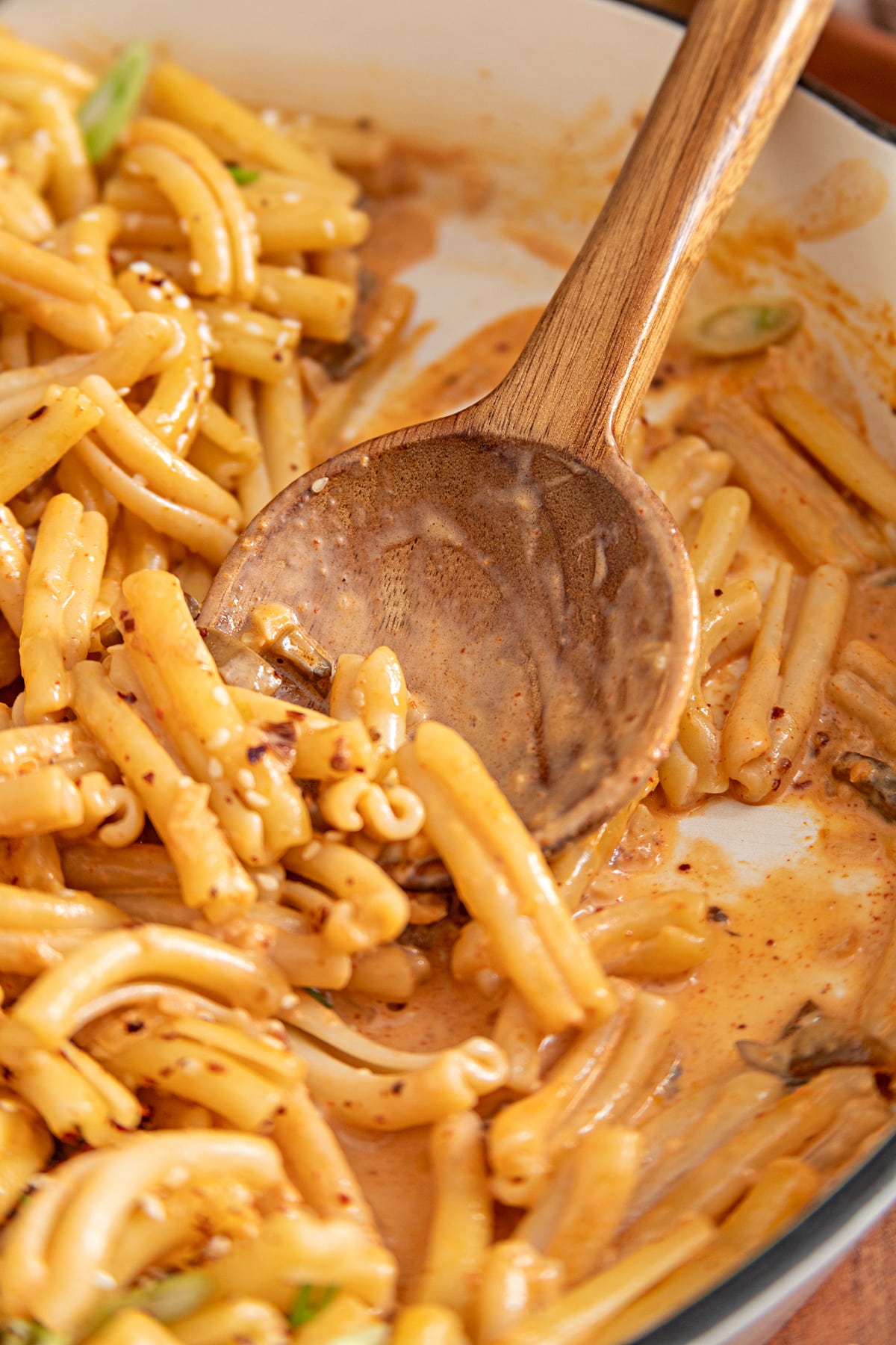 Casarecce and mushrooms coated in creamy gochujang sauce as the pasta is stirred in the skillet