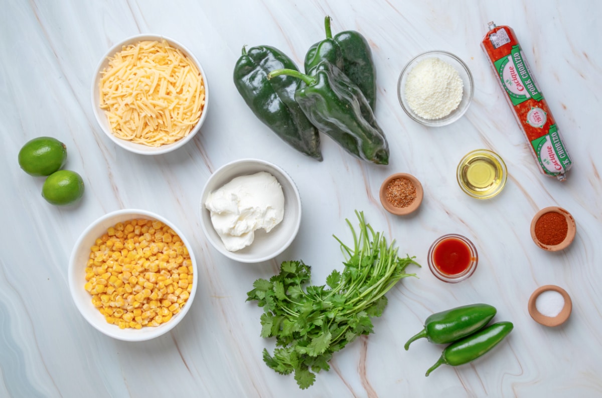 Ingredients for elote-style stuffed poblanos with pork chorizo, corn, three cheeses, jalapeño, lime and cilantro Ingredients for Mexican street corn stuffed poblano peppers including poblanos, corn, chorizo, cream cheese, shredded cheese, Cotija, jalapeños, cilantro and lime