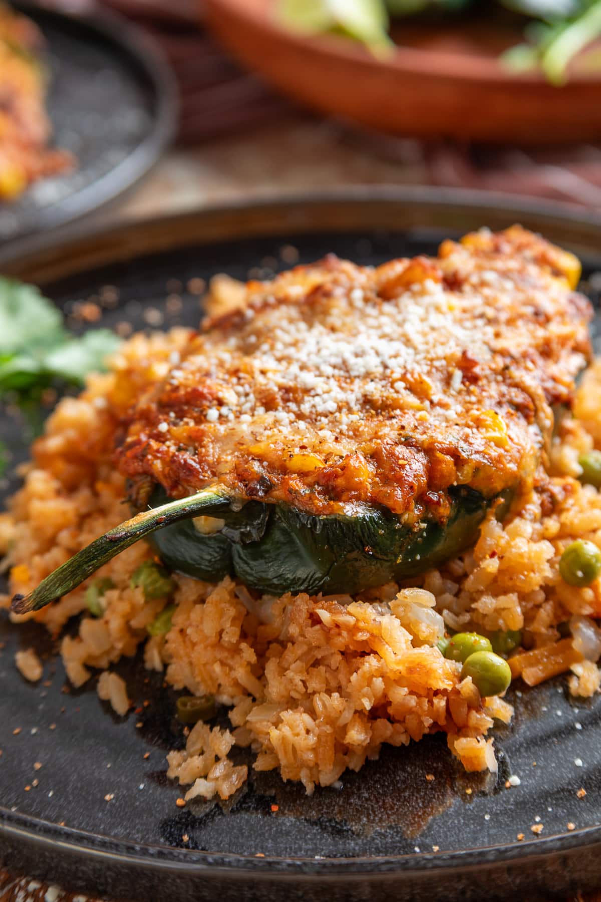 Poblano pepper filled with creamy Mexican street corn, pork chorizo and cheese, served over Mexican rice Mexican street corn stuffed poblano peppers with chorizo, corn, melted cheese, Cotija and Tajín