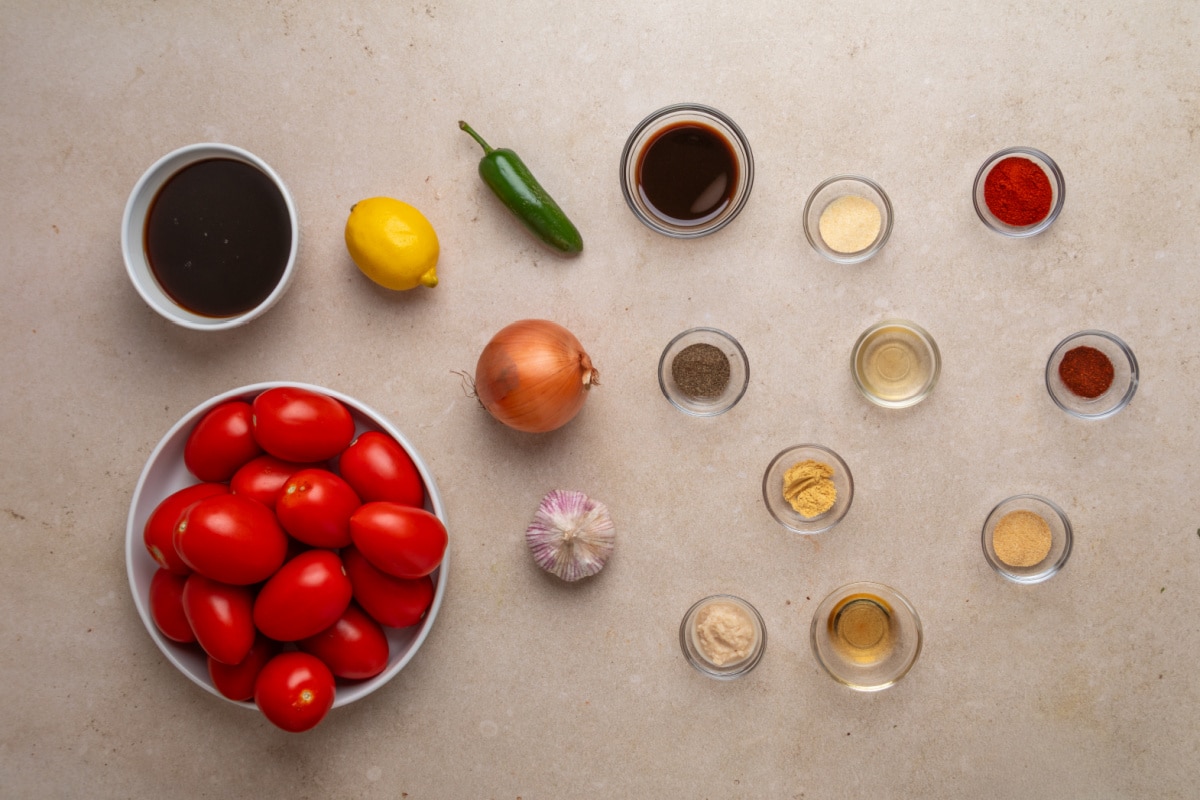 Ingredients for smoked tomato Bloody Mary mix including Roma tomatoes, onion, garlic, jalapeño, lemon, Worcestershire and spices