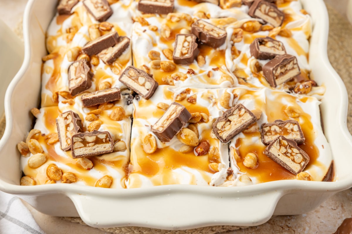 snickers-poke-cake-caramel-peanut-topping