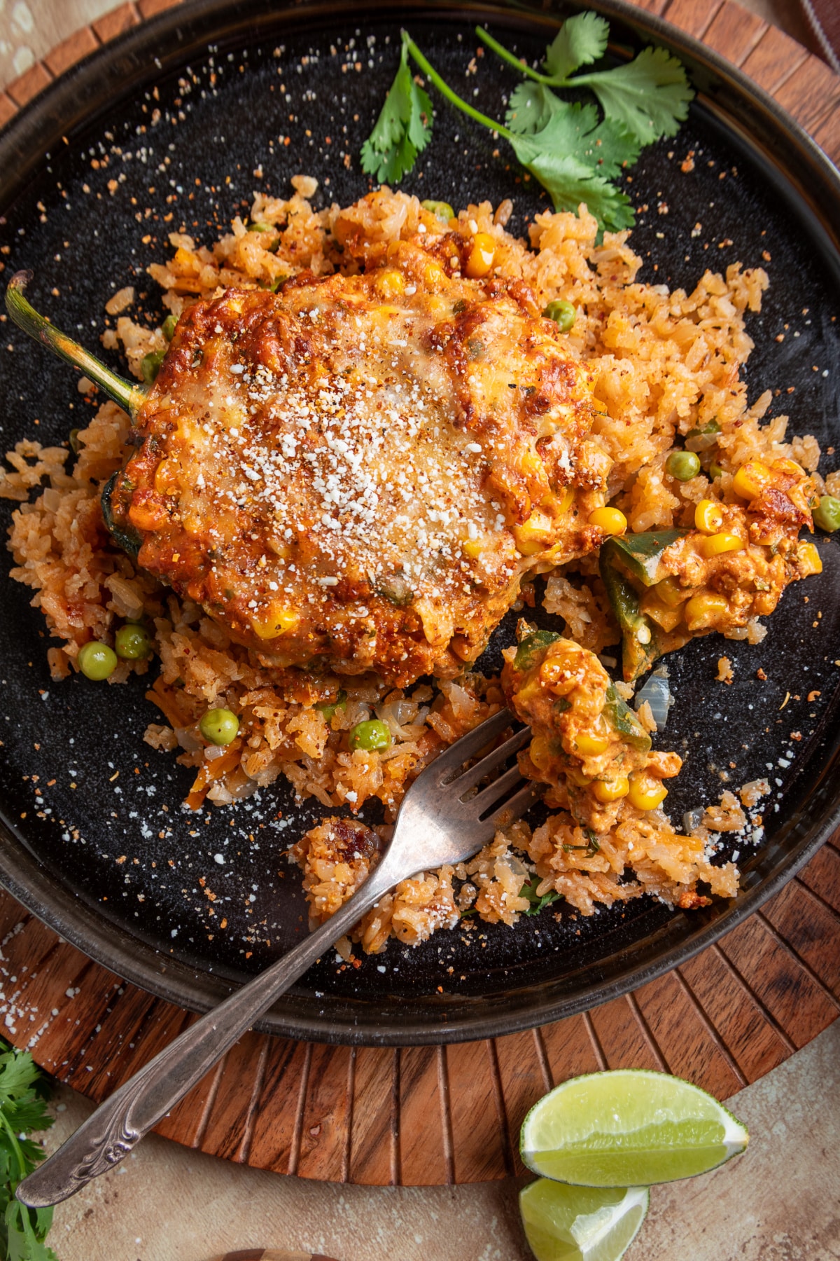 Inside the stuffed poblano with creamy corn, chorizo and cheese filling spilling onto Mexican rice Cheesy chorizo and corn stuffed poblano pepper topped with Cotija and Tajín and served over Mexican rice