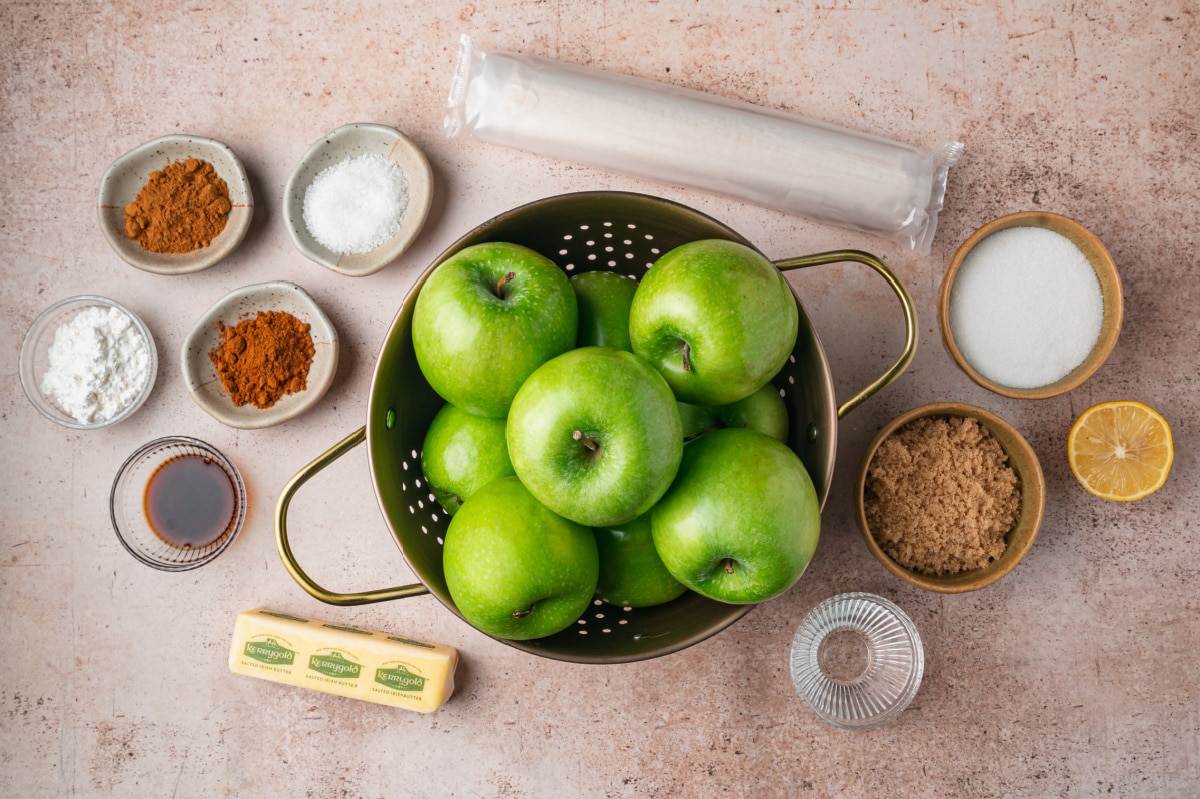 Ingredients for apple pie samosas including Granny Smith apples, phyllo dough, butter, brown sugar, cinnamon, apple pie spice, lemon and vanilla.