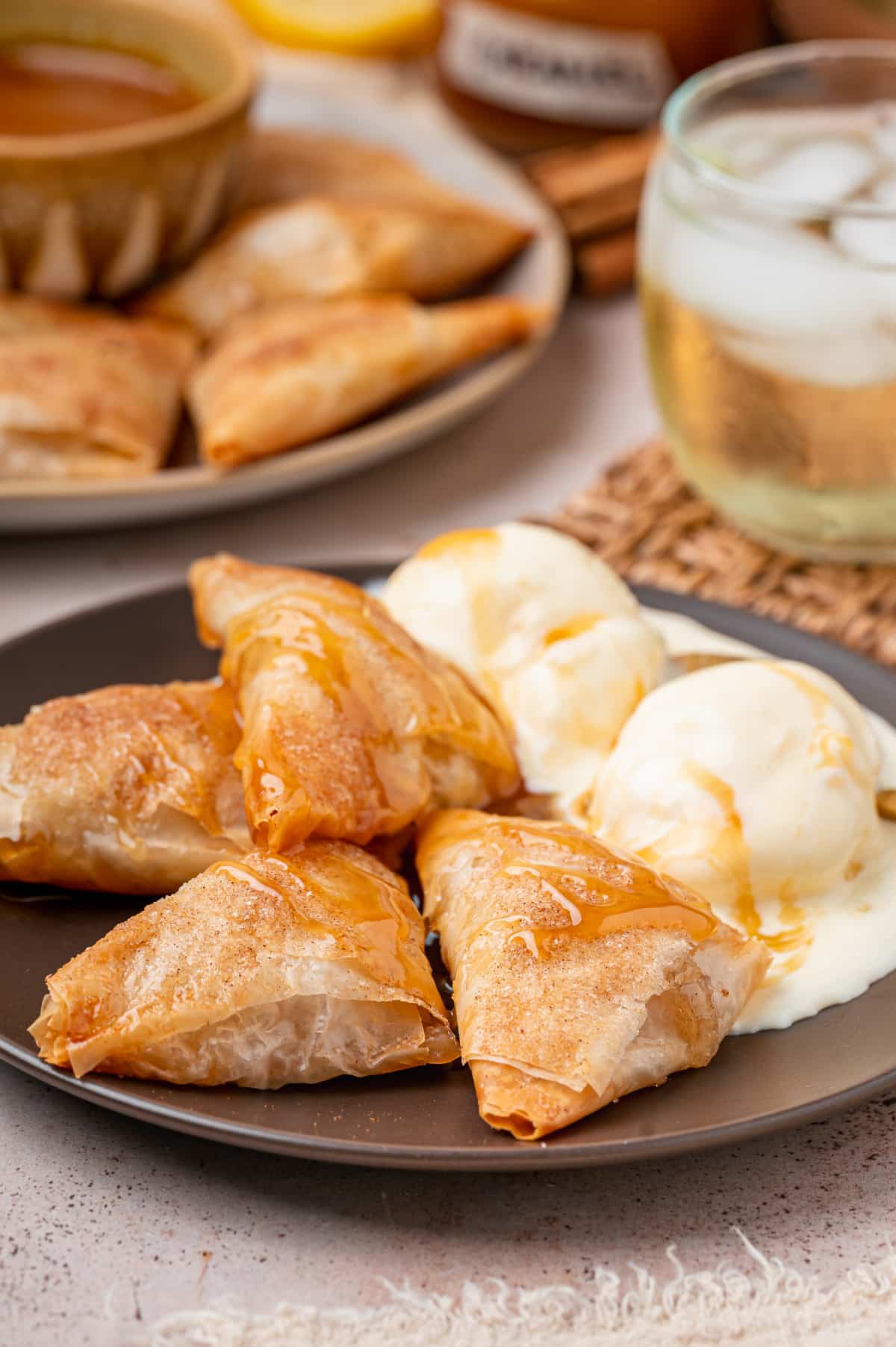 Warm apple pie samosas drizzled with caramel sauce and served with vanilla ice cream.