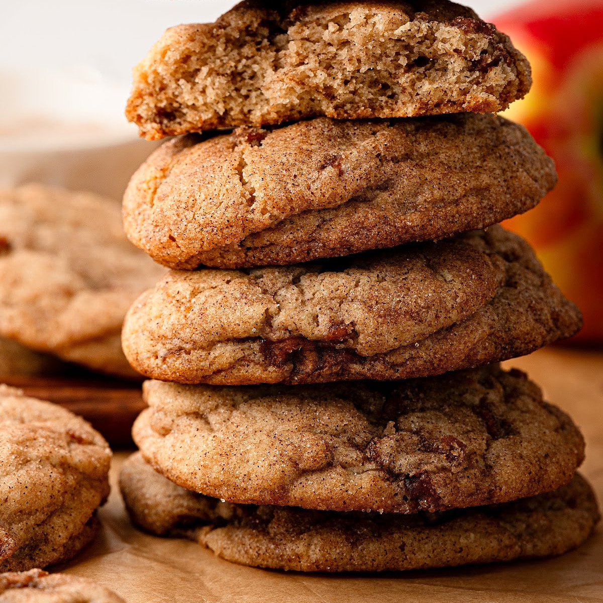 Apple snickerdoodles stacked to show their thick, soft texture and cinnamon-spiced apple pieces