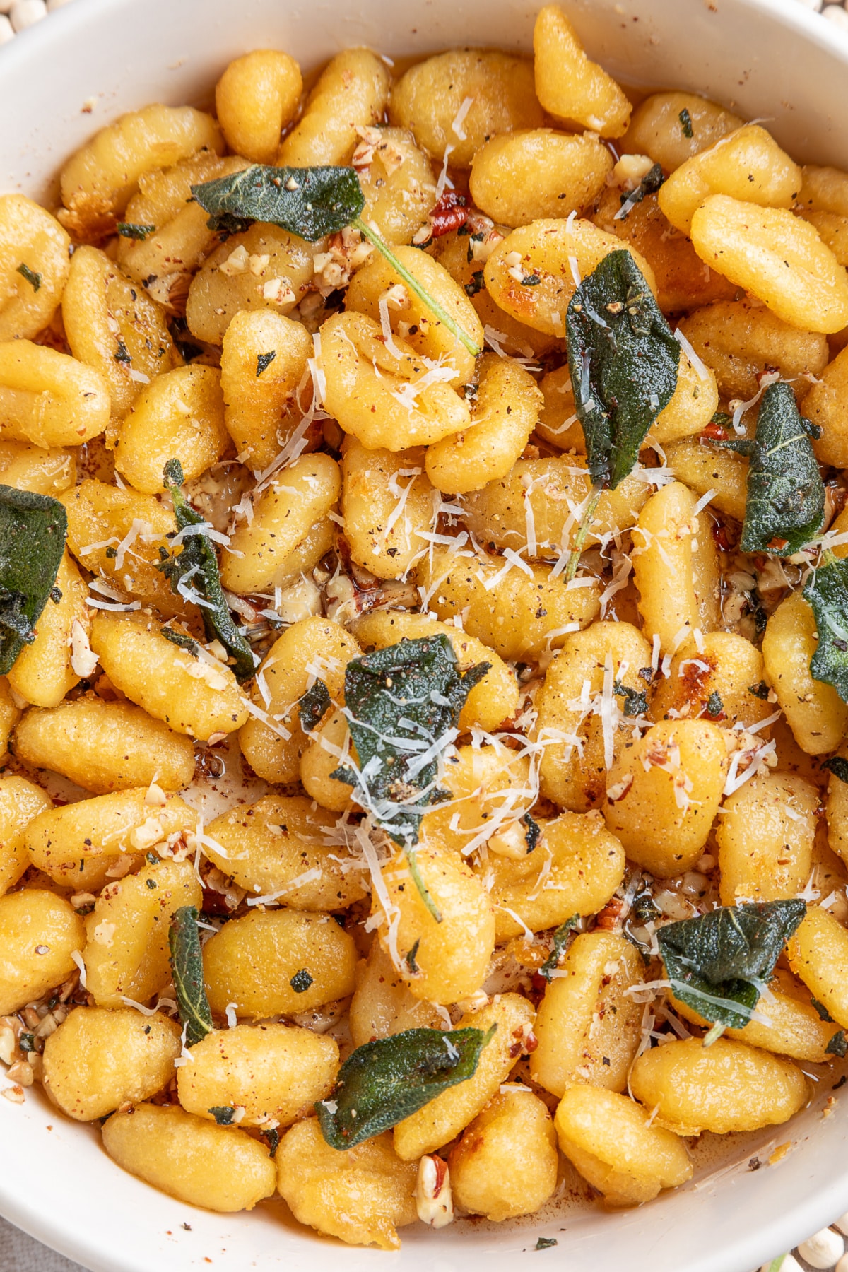 Browned potato gnocchi with fried sage, toasted nuts and grated Parmesan. Crispy gnocchi with sage brown butter topped with fried sage, Parmesan, walnuts and pecans.