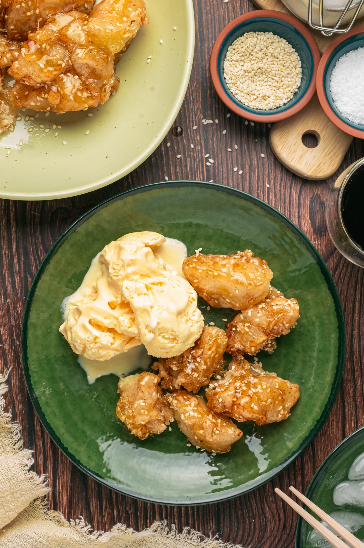 Sesame caramel-coated fried apples served with scoops of vanilla ice cream