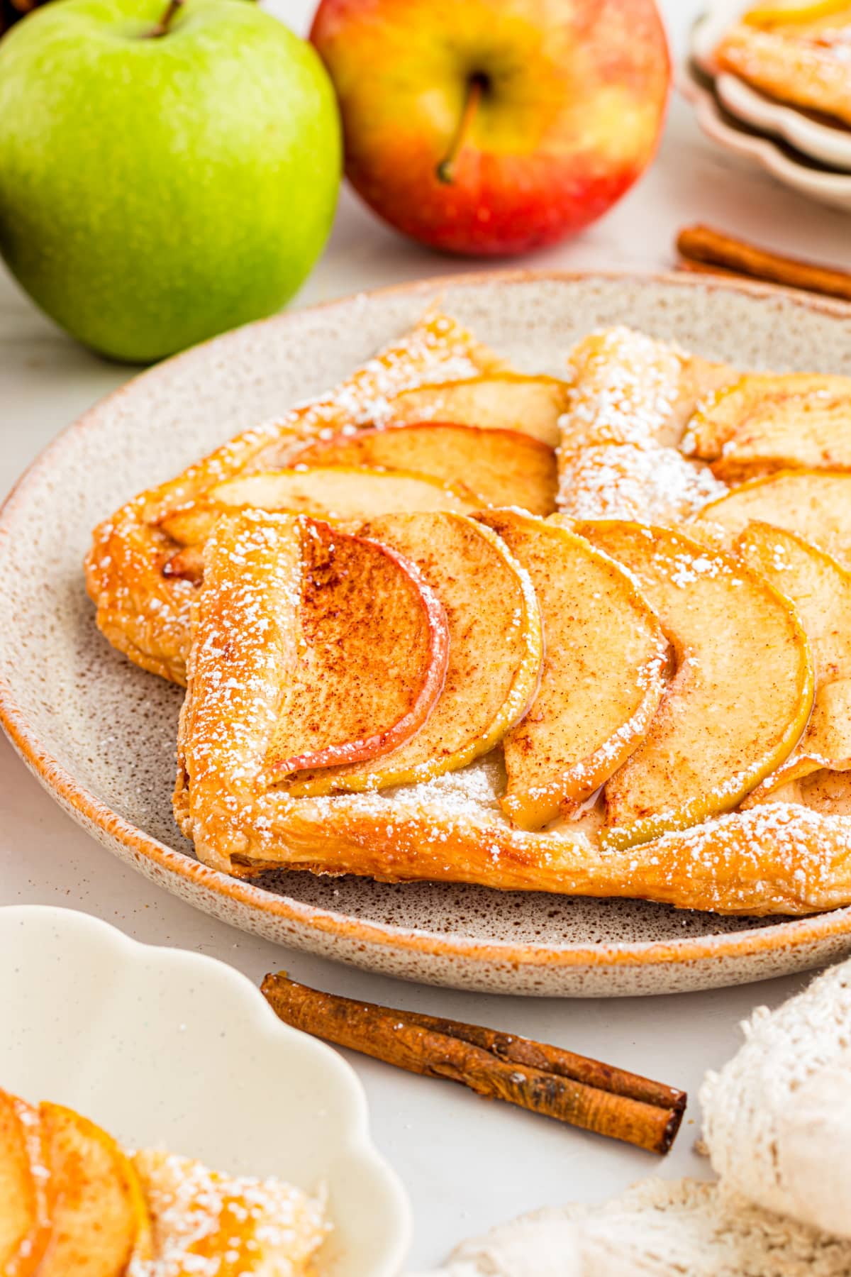 Puff pastry apple tart slice with Granny Smith and Dazzle apples Slice of puff pastry apple tart with cinnamon apples and powdered sugar
