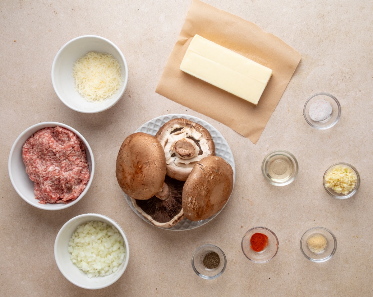 Ingredients for grilled sausage stuffed portobello mushrooms including Italian sausage, portobellos, mozzarella and Parmesan