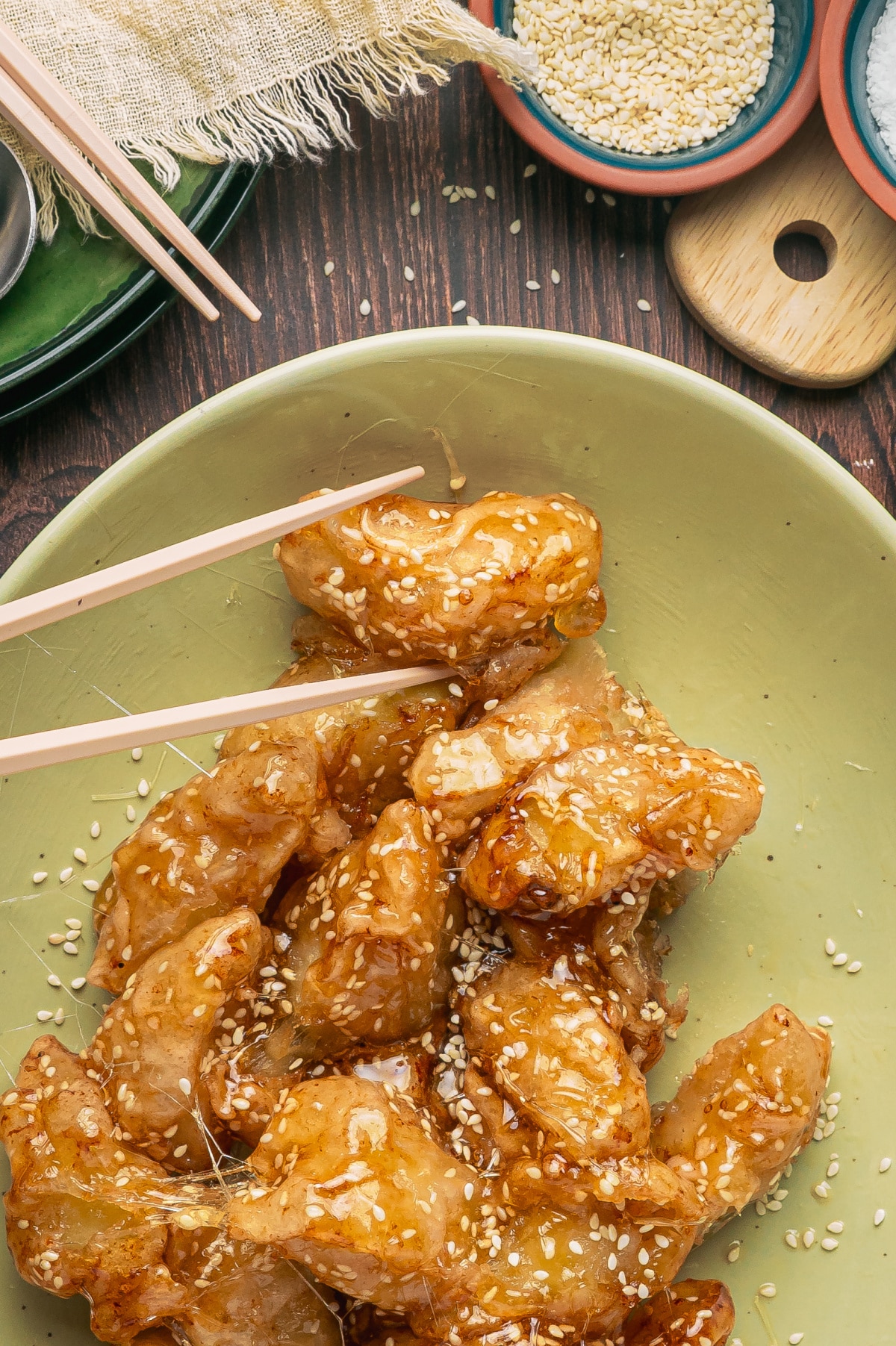 Fried apple pieces coated in brittle sesame caramel with thin strands of pulled sugar
