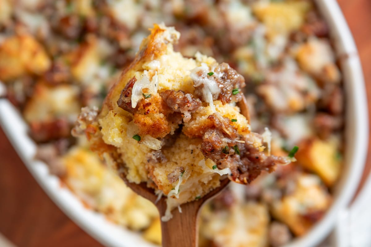Spoonful of cornbread breakfast casserole with sausage, melted cheese and chives