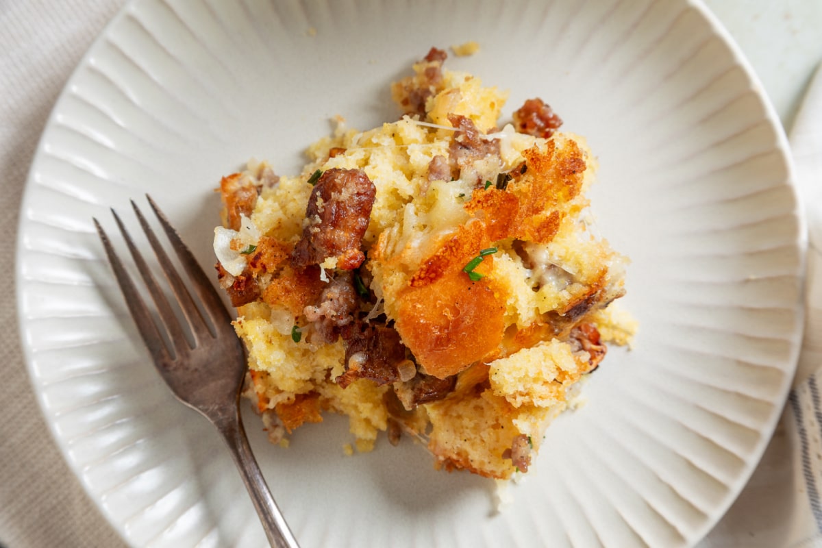 Serving of cornbread breakfast casserole with sausage, melted cheese and browned cornbread