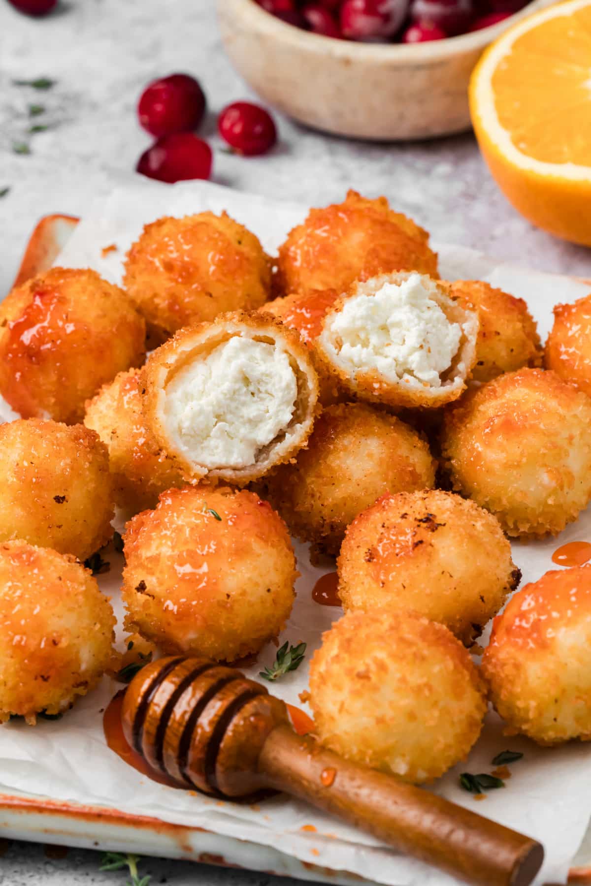 Fried goat cheese balls with crispy panko coating, creamy goat cheese centers, and cranberry hot honey drizzled over the top.