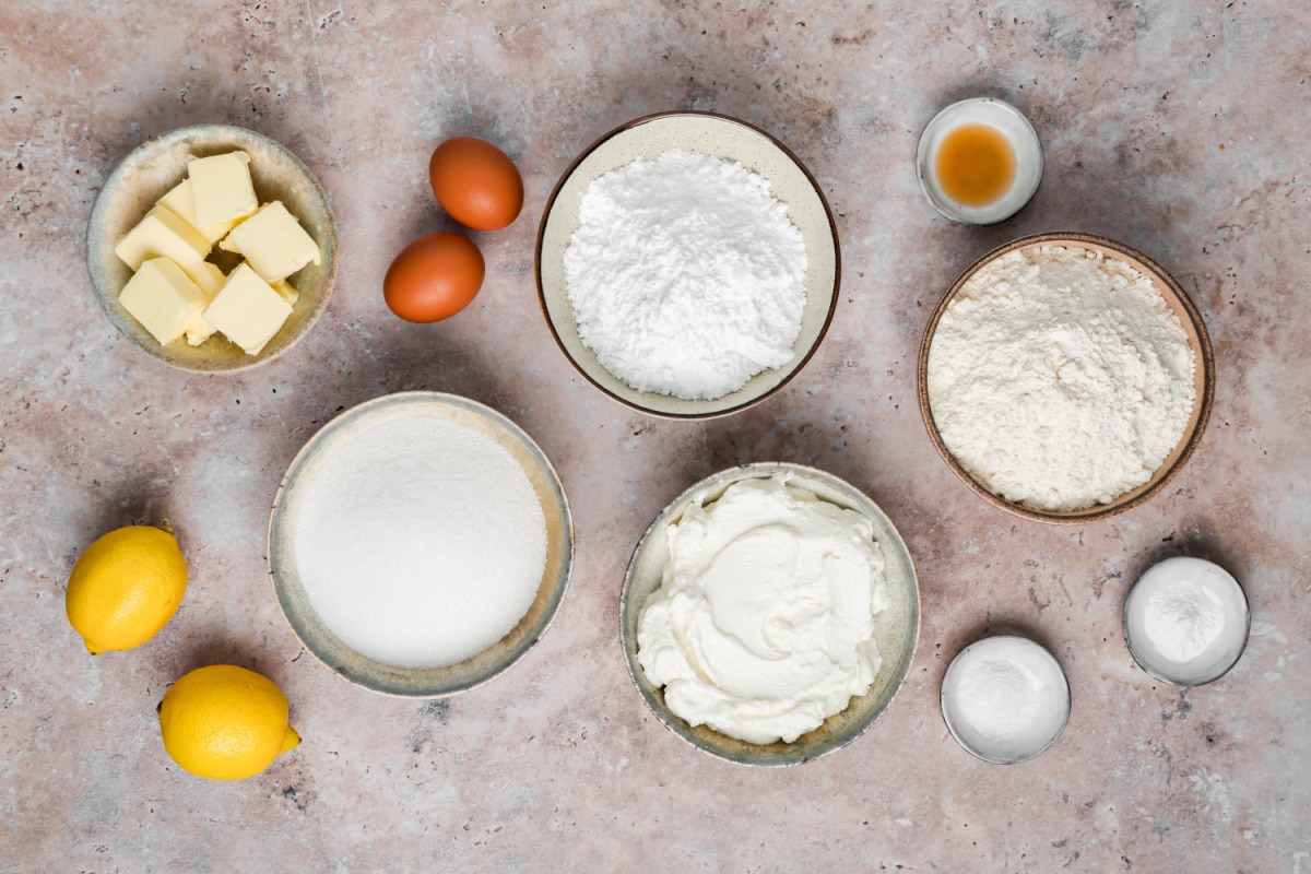 Ingredients for lemon ricotta cookies including ricotta, fresh lemons, flour, sugar, butter and eggs