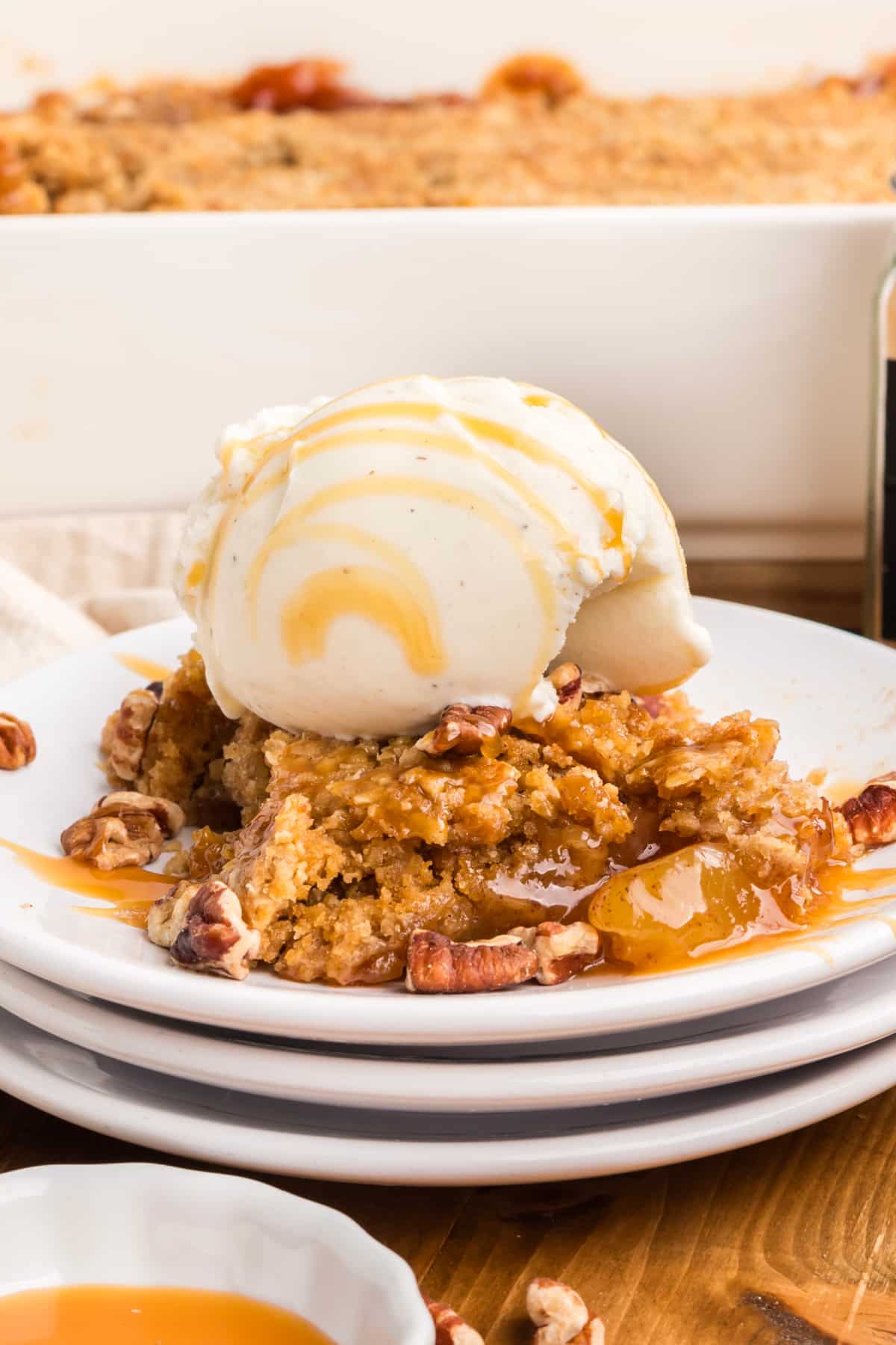 Warm oatmeal cookie apple crisp dump cake with a cracked cookie crust, cinnamon apples, vanilla ice cream, caramel, and pecans. oatmeal-cookie-apple-crisp-dump-cake-vanilla-ice-cream-caramel